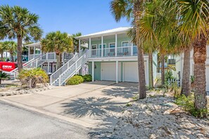 A beachfront property with a two-story building, a covered porch, and a driveway. - 🔥 🏖️ Gone To The Beach: Firepit, Community Pool + Steps to Navarre Beach! (Navarre Beach)