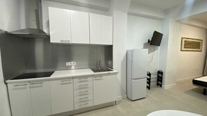 A modern kitchen with white cabinets, a stainless steel range hood, a built-in sink, and a white refrigerator. - Studio MARQ CASTILLO Alicante Playa. Clean and complete. Well communicated. (Alacant)