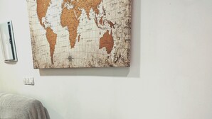 A round white table with wooden legs, a grey chair, and a world map on the wall. - Studio MARQ CASTILLO Alicante Playa. Clean and complete. Well communicated. (Alacant)