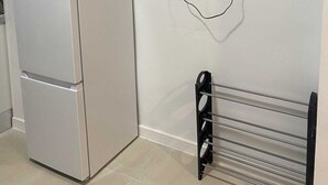 A kitchen with a white refrigerator, a wall-mounted TV, and a metal rack. - Studio MARQ CASTILLO Alicante Playa. Clean and complete. Well communicated. (Alacant)