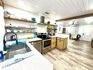 A kitchen with wooden cabinets, stainless steel appliances, and a sink. - Serenity by the Shore, 3 Bdr, Walk to Beach! (Port Orange)