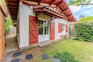 A house with a red door, white walls, and a red roof. - Holiday Home “Villa Les Arbousiers Moulleau 300 m” with Terrace, Private Garden & Wi-Fi (Arcachon)