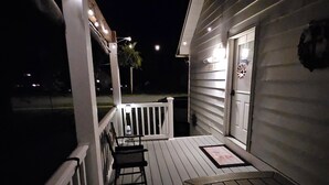 A wooden deck with a railing, a bench, and a door leading to a building. -  Charming 3 bed/2 bath house in Rock Hall with a 3-min walk to restaurants/town. (Rock Hall)