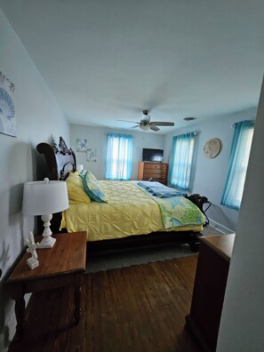 A bedroom with a bed, a ceiling fan, a dresser, a lamp, and a wall clock. -  Charming 3 bed/2 bath house in Rock Hall with a 3-min walk to restaurants/town. (Rock Hall)
