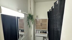 A bathroom with a white sink, a toilet, a mirror, and a shower curtain. - Central and comfortable apartment for two or three people (Lausanne)