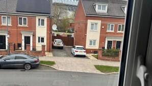A residential street with houses, parked cars, and a visible satellite dish. - Cozy Home Walk to Anfield and Liverpool Attractions (Liverpool)