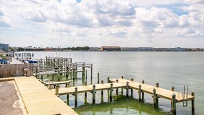 A marina with wooden docks and boats, a clear sky, and buildings in the background. - Bayfront Condo with Great Location in Ocean City (Ocean City)