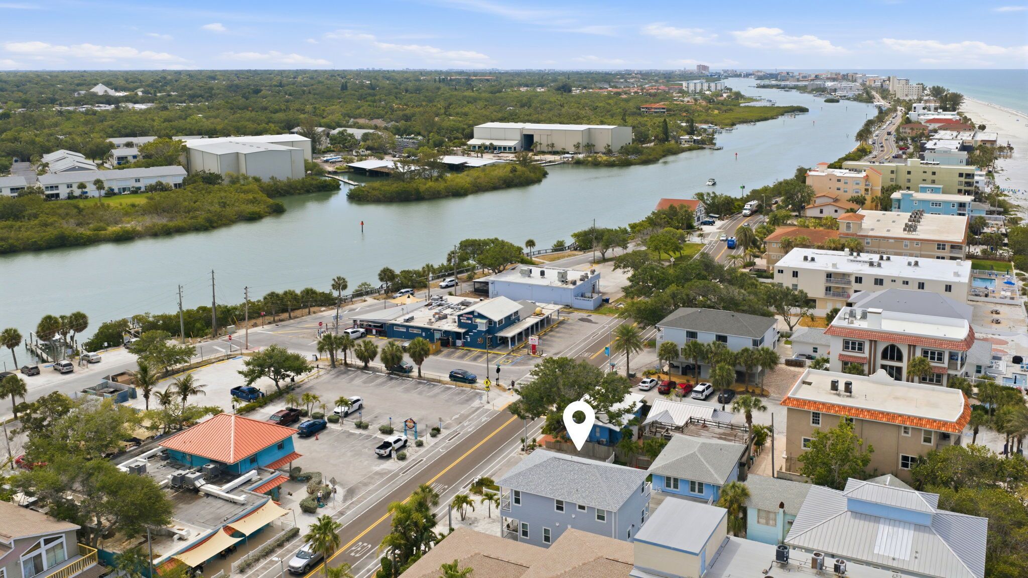 Un pueblo costero con un río, edificios y una playa.