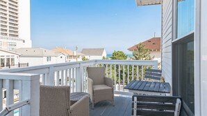 Un balcon doté de meubles en osier et offrant une vue sur l’océan.