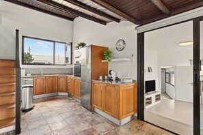 A kitchen with wooden cabinets, a stainless steel refrigerator, a sink, and a window. - Vacation Apartment 'Guada' with Private Terrace, Wi-Fi and Air Conditioning (Tao)