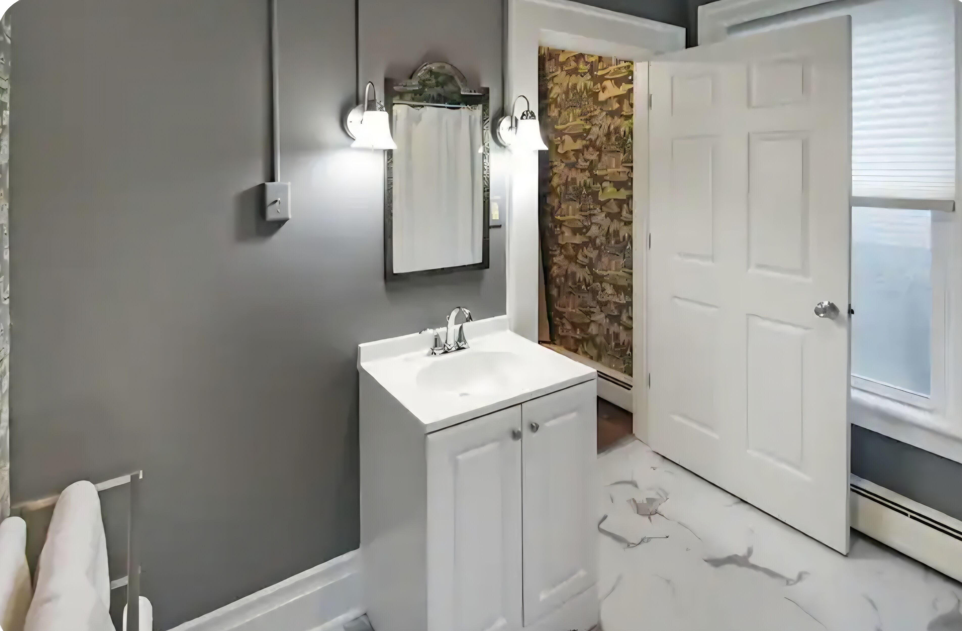 A bathroom with a white sink, a mirror, and a towel rack.