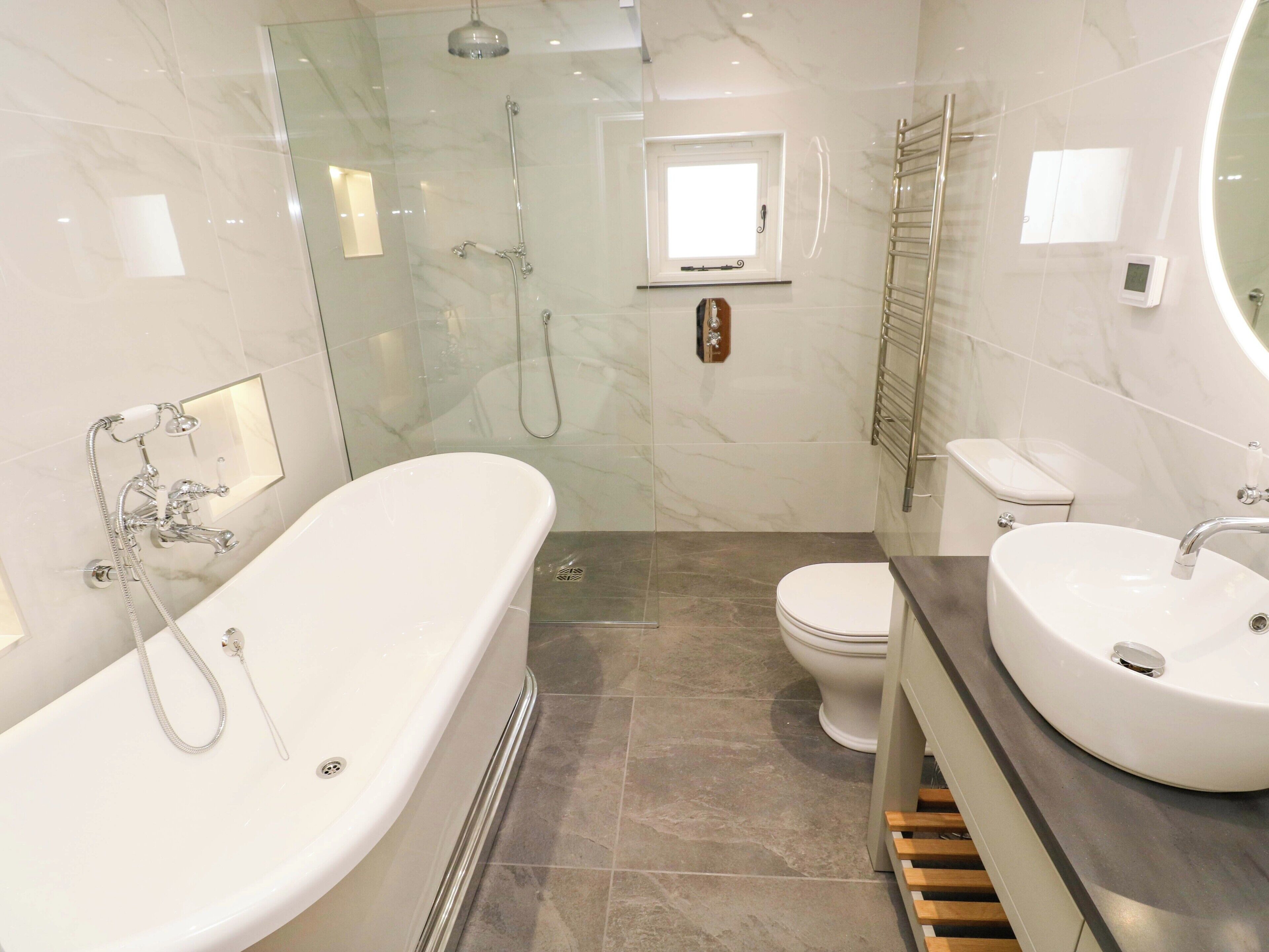 A modern bathroom with a freestanding bathtub, a toilet, and a sink.