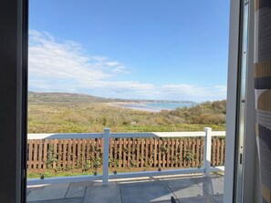 A balcony with a view of a beach and hills. - Wernlas Lodge (Swansea)