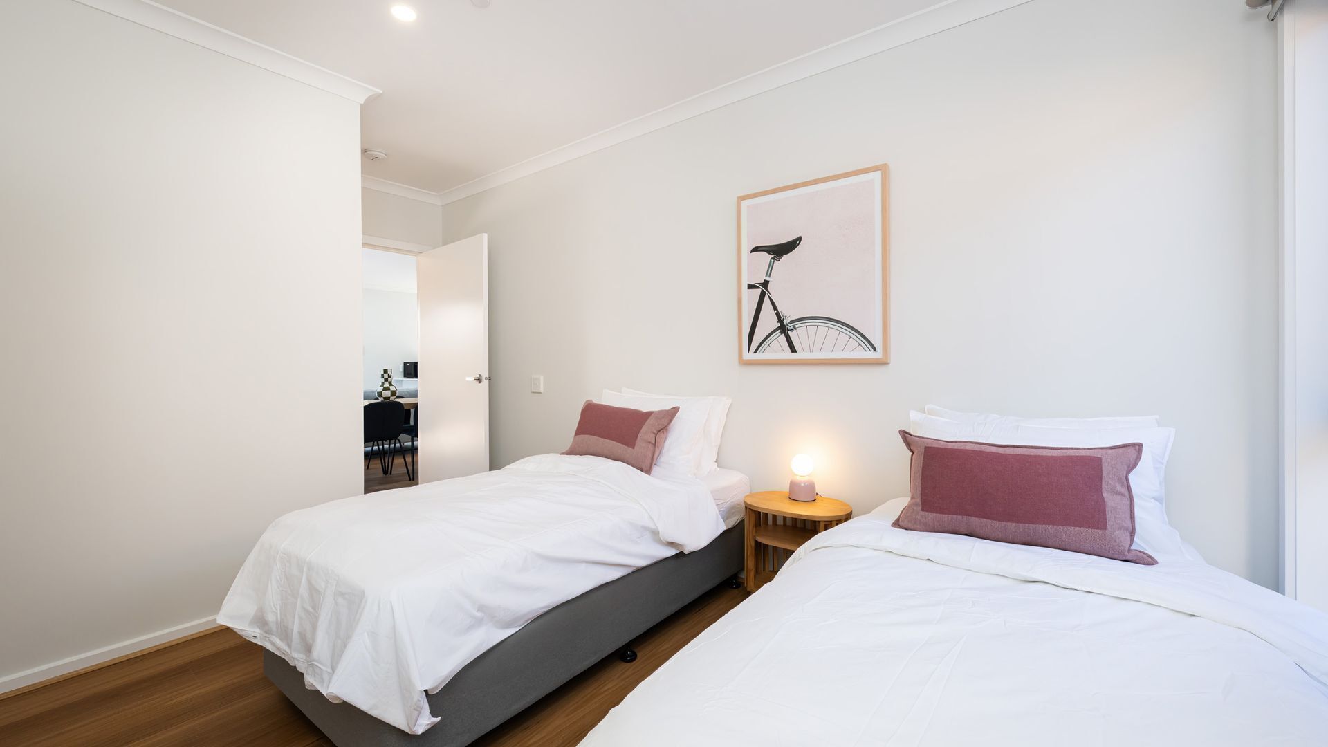 A bedroom with two beds, a desk, and a chair.