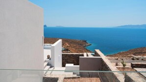 A modern building with a glass balcony overlooking a coastal landscape. - MZ Deep Blue (Kithnos)