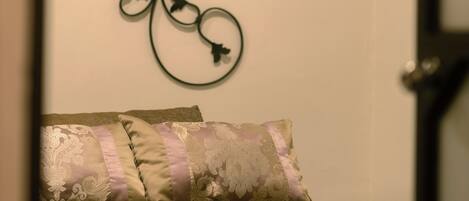 A bedroom with a bed, decorative wall art, and a partial view of a door.