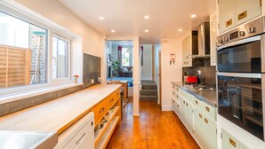 Una cucina moderna con un lungo bancone, forno integrato e vista sull'area pranzo.