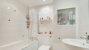 Un baño con bañera, inodoro y lavabo.