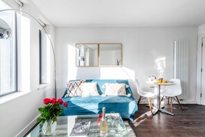 Ein modernes Schlafzimmer mit Bett, Nachttisch und einer kleinen Essecke mit Tisch und Stühlen.