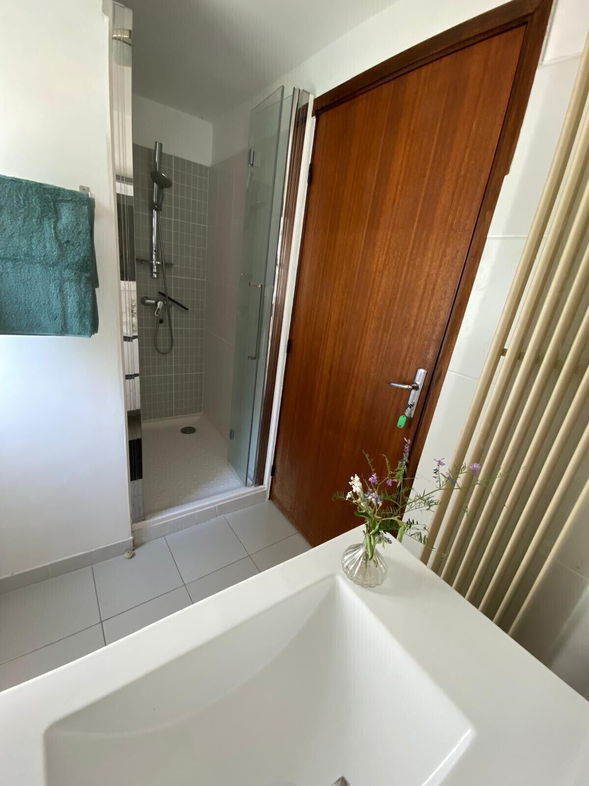A bathroom with a bathtub, a shower, and a wooden door.