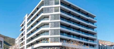 A multi-story building with a modern architectural design, featuring a prominent signage for 'The Sage' on the ground floor.