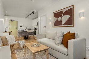 Una sala moderna con sofá, mesa de centro y comedor.
