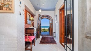 A hallway with a view of the sea, a wooden door, and a red rug. - Yzerfontein 3 Bed House With Pool Sea Views (Yzerfontein)