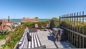 A rooftop terrace with a view of the sea, outdoor furniture, and a wooden fence. - Yzerfontein 3 Bed House With Pool Sea Views (Yzerfontein)