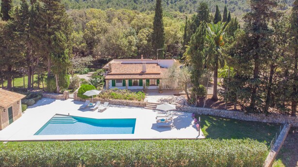 A villa with a swimming pool, surrounded by trees and a mountainous backdrop. - Finca Ca l'Hereu Petit 282 by Mallorca Charme (Cala Sant Vicenç)