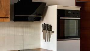 A kitchen with a microwave, oven, and knife rack. - Apart Vinschgau (Val Venosta) - charming, cozy apartment with mountain view (Laudes)