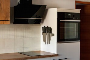 Cozinha equipada com micro-ondas, forno e suporte para facas.