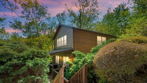 Une cabane dotée d’un porche, entourée d’une végétation luxuriante.