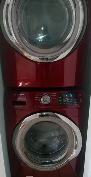 Une machine à laver Samsung rouge, dotée d’un écran numérique et d’un panneau de commande.
