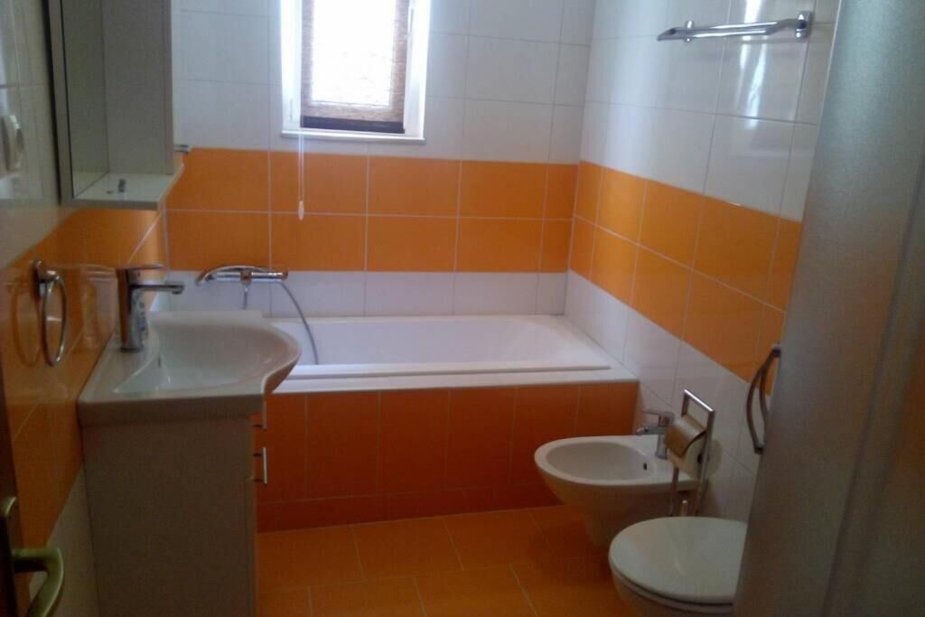 Et badeværelse med badekar, vask og toilet.