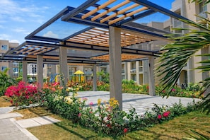 A covered outdoor area with a playground, surrounded by a variety of flowers and plants. - The Colombian Dream in Cartagena, Modern 2-bed, 2-bath apartment + home office (Bolivar)