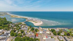 Une vue aérienne d’une ville côtière, avec une plage, des quartiers résidentiels et une église imposante.