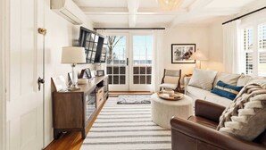 Un salon comprenant un canapé, une table basse, une lampe, une cheminée et une vue sur l’extérieur.