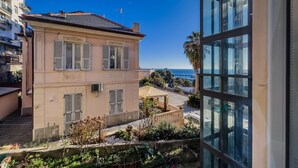 A two-story building with a balcony, a view of the sea, and a garden area. - [Ospedale S. Paolo 2 min] HiperWifi • SmartTV • AC (Savona)