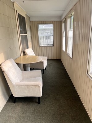 A room with a beige carpet, a round table, and two white armchairs. - Serene 3-bedroom house in charming Syracuse (Syracuse)