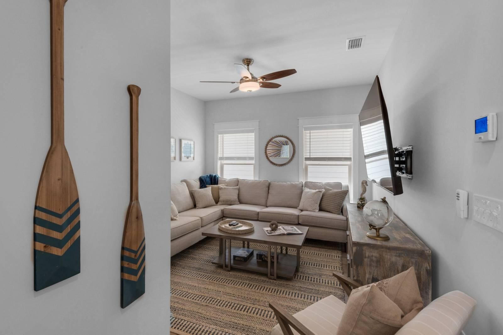 A living room with a sofa, coffee table, and a ceiling fan.