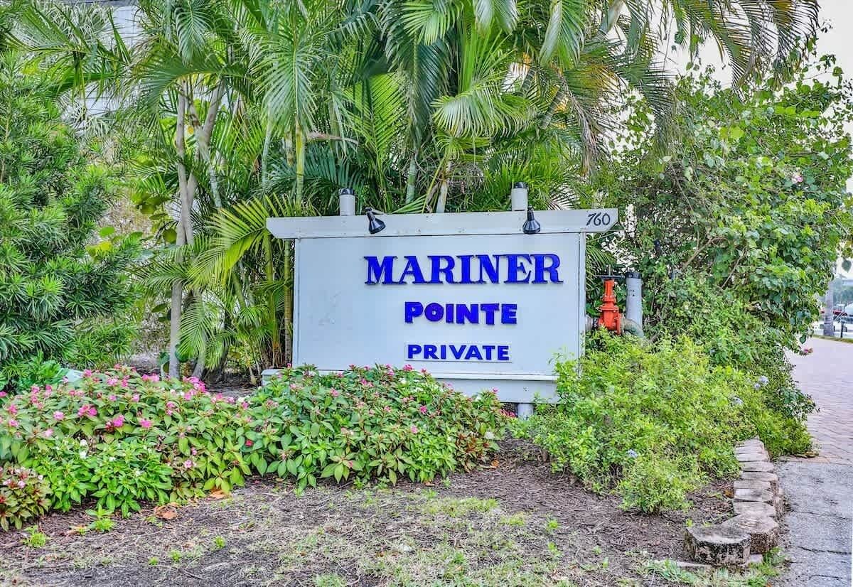 A sign for 'MARINER POINTE PRIVATE' with a lush garden and palm trees.