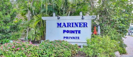 A sign for 'MARINER POINTE PRIVATE' with a number '760' and surrounded by lush greenery.