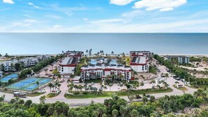 Un resort con varias construcciones, una piscina y vistas al océano.