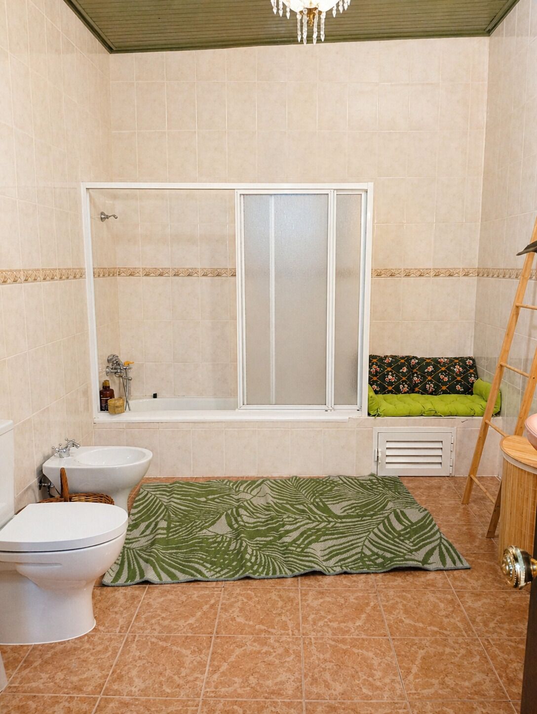 Casa de banho com banheira, sanita, bidé e cabine de duche.