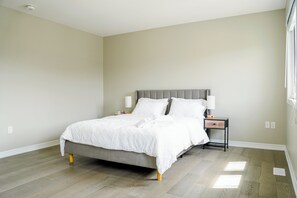 Un dormitorio con cama, mesita de noche y lámpara.