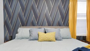 A bed with a patterned headboard, multiple pillows, and a blanket. - Luxe Downtown Townhome-Sleeps 6 Brand New Build! (Indianapolis)