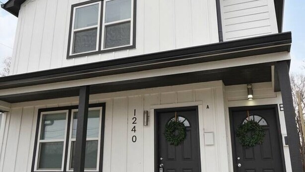 A two-story house with a front porch, two front doors, and a number '1240' on the wall. - Luxe Downtown Townhome-Sleeps 6 Brand New Build! (Indianapolis)