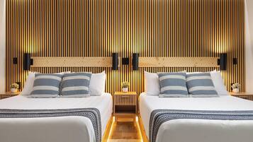 Habitación de hotel con dos camas, paneles de madera en las paredes y lámparas de noche.
