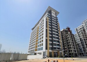 A multi-story hotel with a modern design, featuring a prominent entrance and a visible name sign. - Boutique Affini Studio w/ Balcony, Pool & Gym (Dubai)