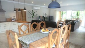 A dining area with a wooden table, chairs, and a bowl of fruit. - Beautiful villa near Meia Praia, Lagos with solar heated pool & lots of space (Lagos)
